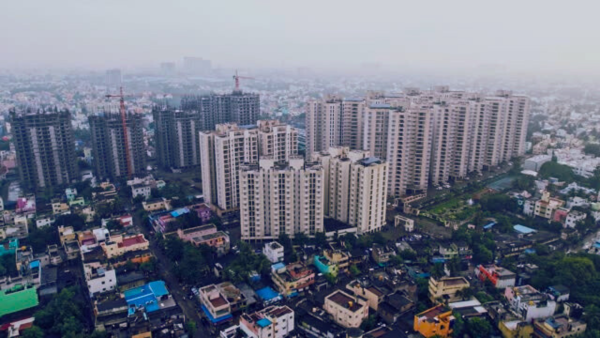 A drone view of the place in India where large buildings are present also there is small house and market are present.