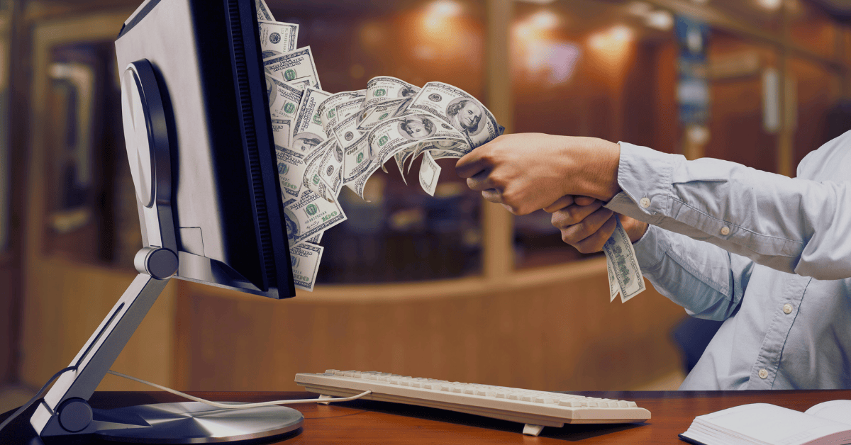 Hand pulling out money from the PC montior